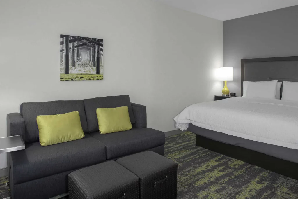 king bedroom with sofa at hampton inn and suites