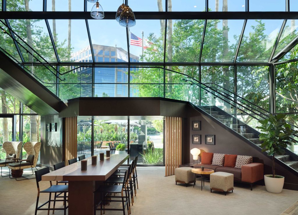 lobby at sonesta irvine with staircase, couch, long tables with chairs