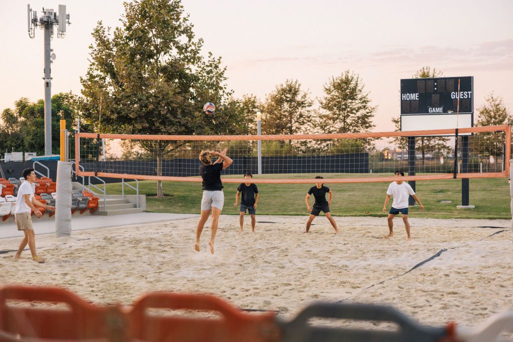 group of males playing volleyball at great park volleyball courts