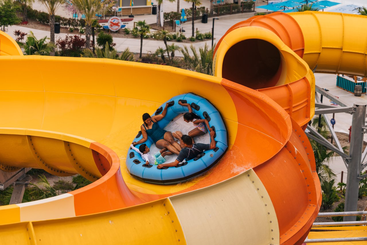 family on a float sliding a waterslide at wild rivers irvine